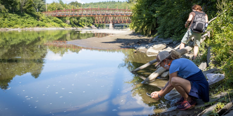 two people exploring the shore of the winooski river