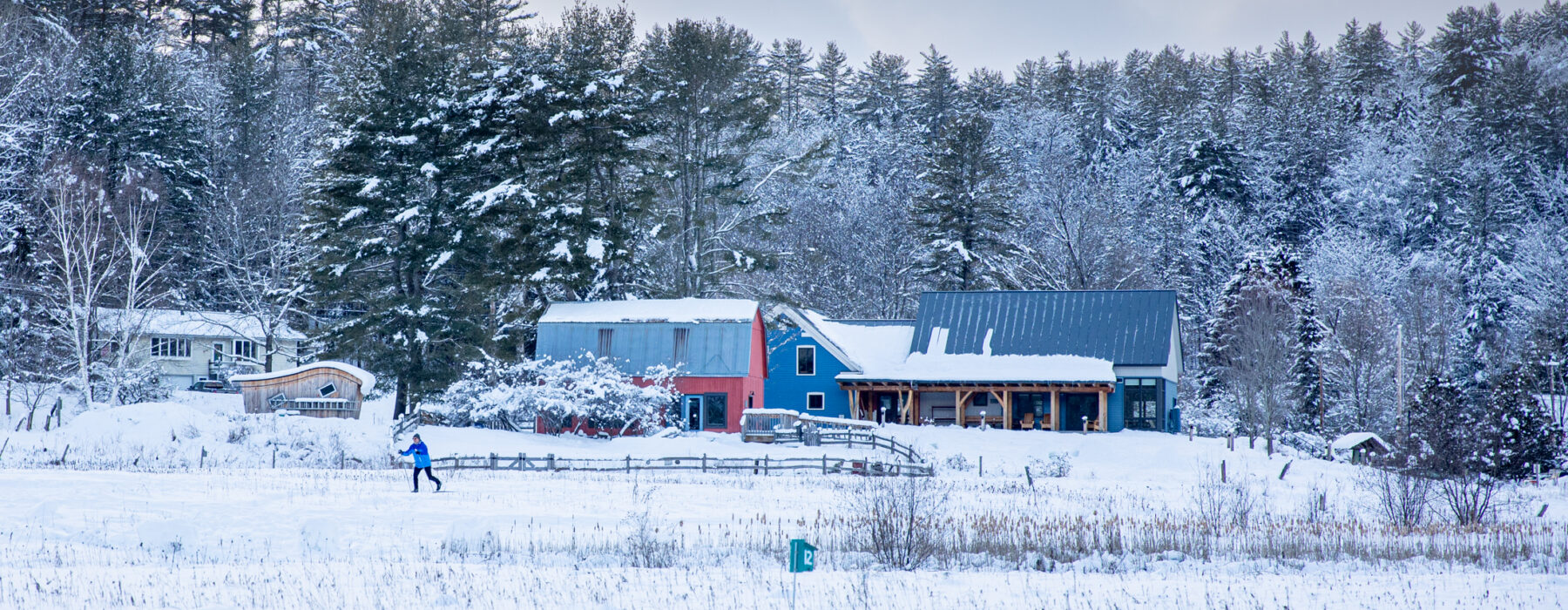 North Branch Nature Center buildings in winter with skiier